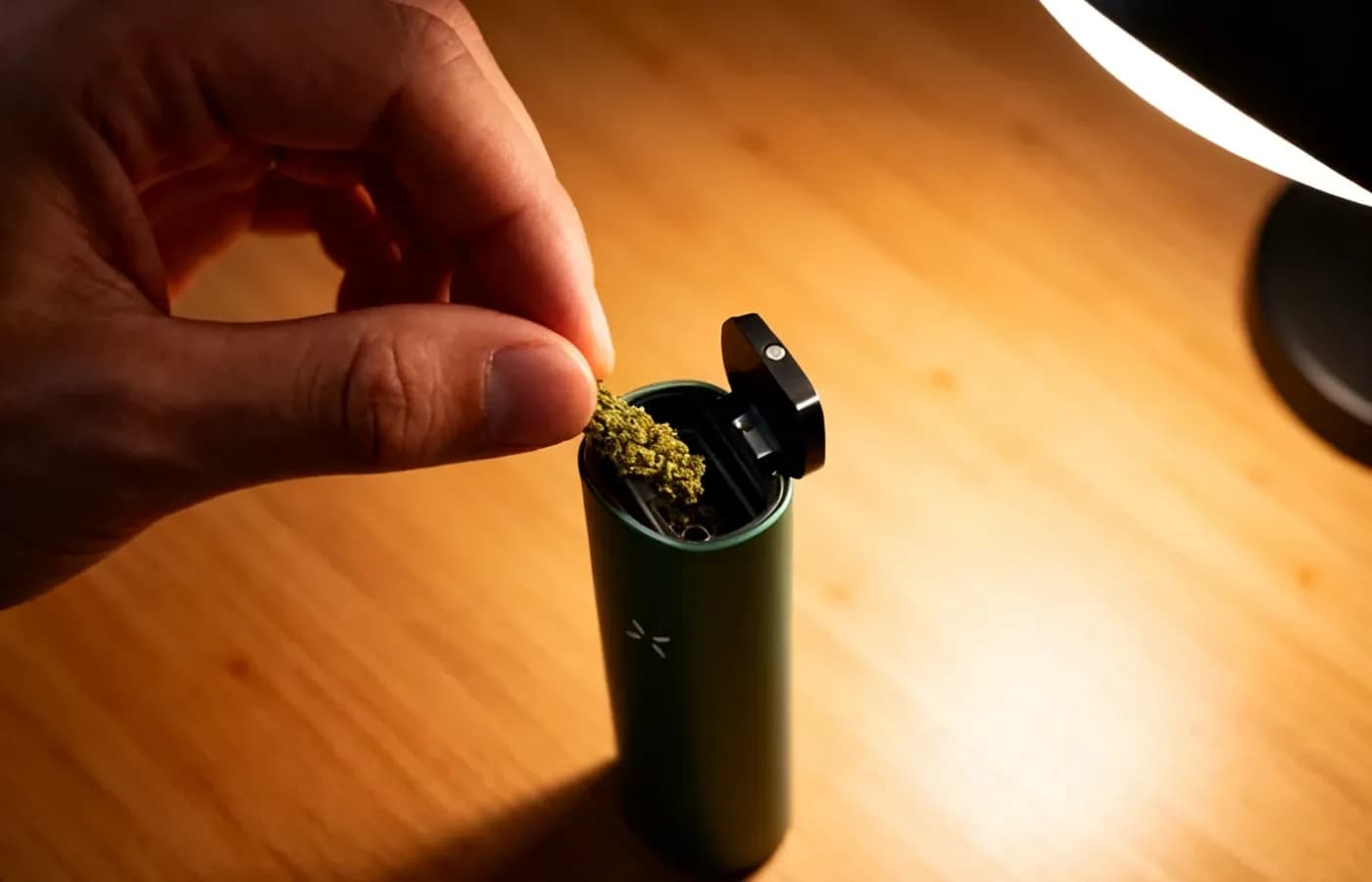 Hand fuellt fein gemahlene Kraeuter in Vaporizer-Kammer